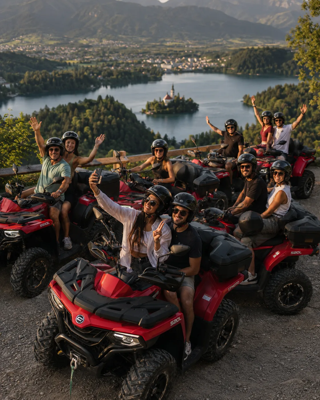 Group of friends waving from red CFMOTO ATVs and Quads at a viewpoint over Lake Bled, Slovenia