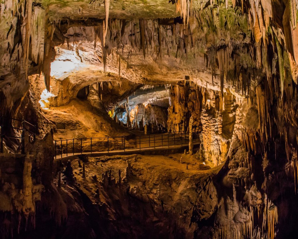 Illuminated rock formations inside Postojna Cave