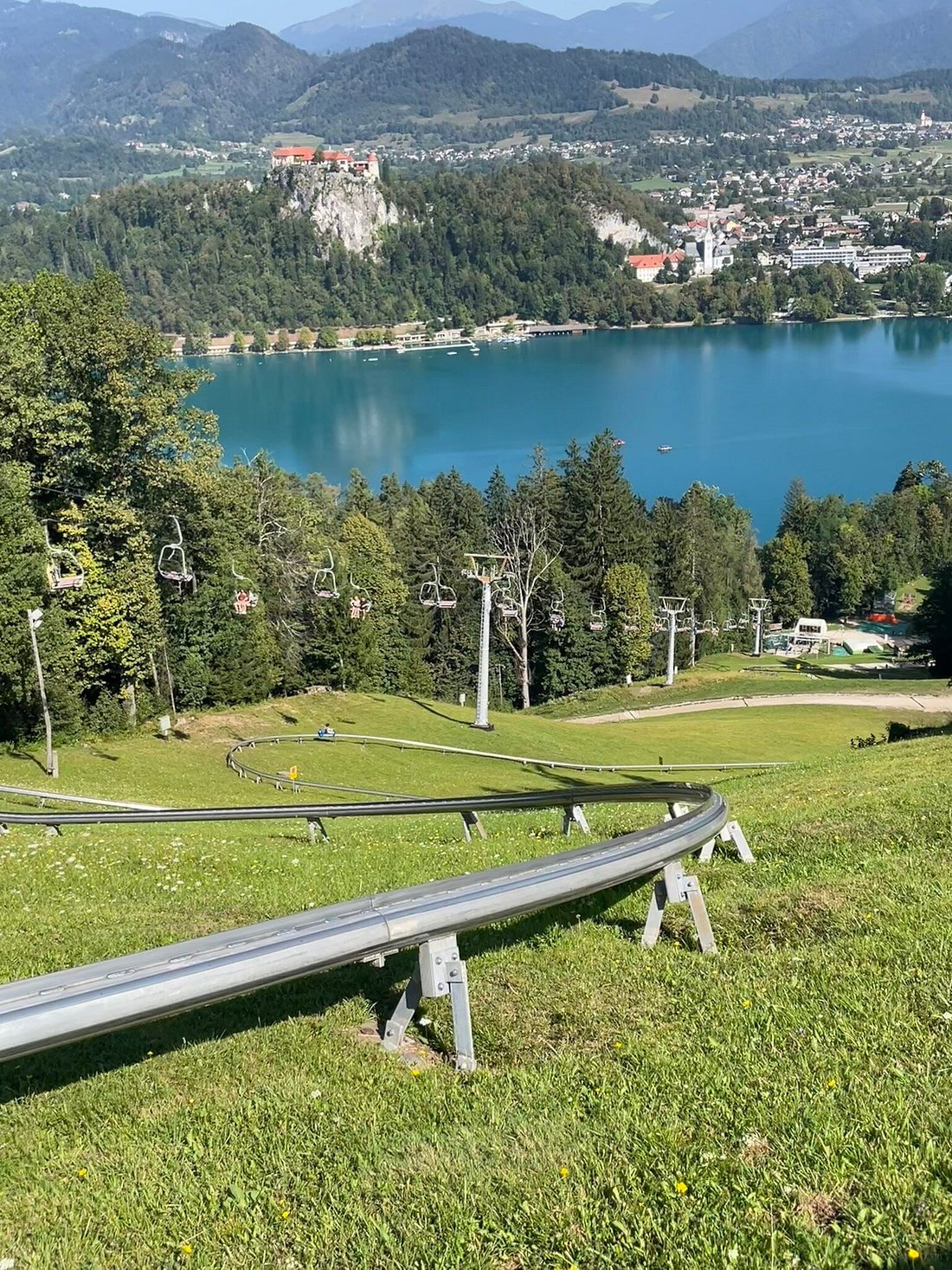 Pista della slittovia estiva sulla Straza con seggiovia e lago di Bled sullo sfondo